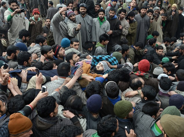 Na Caxemira, pessoas se reúnem em volta do corpo de um militante durante seu funeral em Handoora, na Índia. Ele foi morto por soldados em um tiroteio na terça-feira (27). Um coronel do exército indiano também estava entre as quatro vítimas