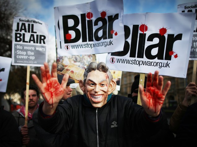 Protestante da Aliança Pare a Guerra (do inglês Stop the War) usa máscara do ex-primeiro ministro Tony Blair com as mãos sujas de sangue próximo ao Parlamento inglês, em Londres