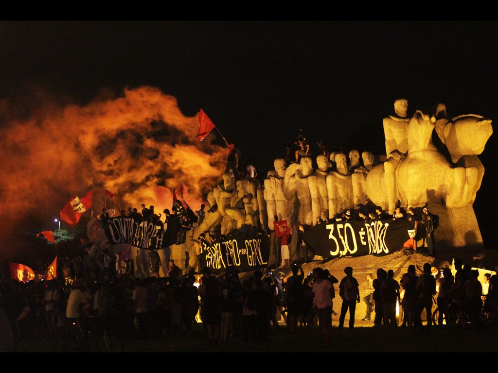 Manifestantes sobem no Monumento às Bandeiras, em frente ao Parque do Ibirapuera, durante o sexto ato organizado pelo Movimento Passe Livre (MPL) contra o aumento da tarifa dos transportes públicos em São Paulo, na Zona Sul da cidade