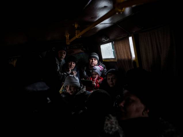 Família tenta fugir em um ônibus da cidade ucraniana de Debaltseve, na região de Donetsk, disputada entre ucranianos e separatistas pró-Rússia