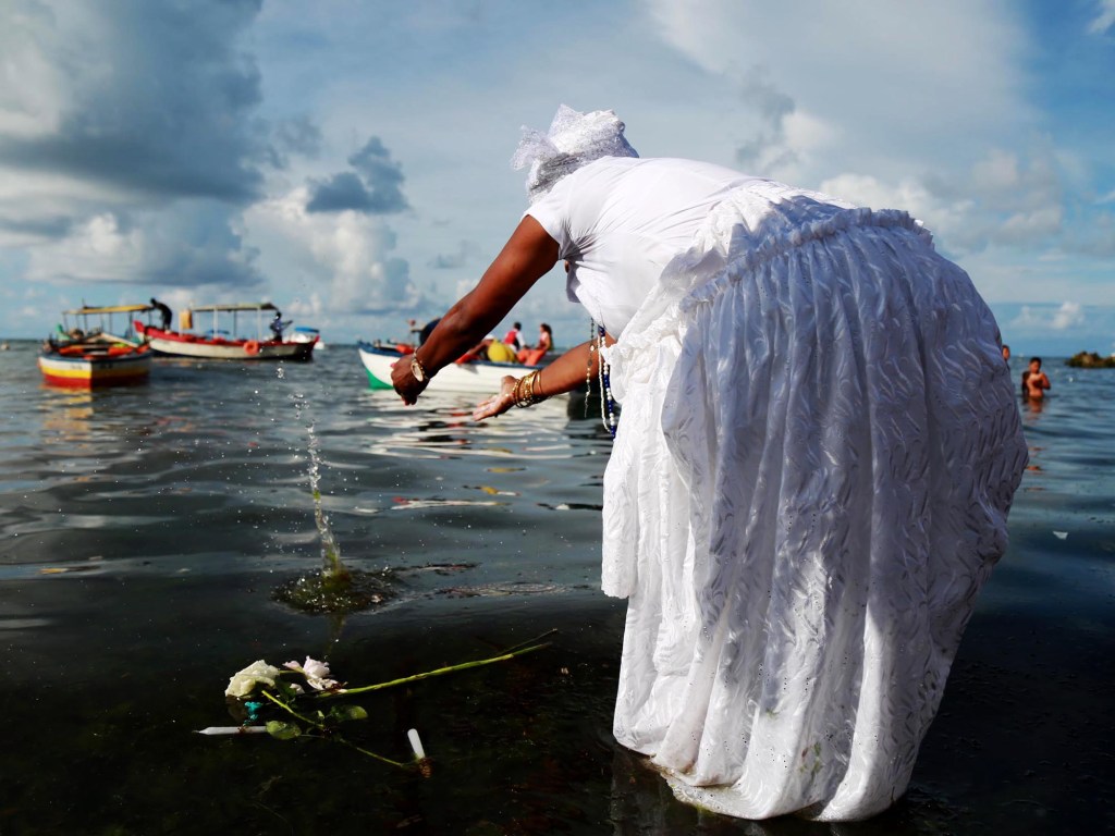 Mulher joga oferenda e rosas para Iemanjá no bairro Rio Vermelho, em Salvador. Cerca de 700 mil pessoas prestigiam o dia da orixá considerada 'rainha do mar' pela tradição do Candomblé