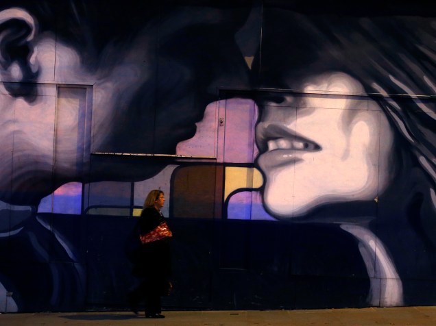 Mulher anda em frente à parede de loja desenhada em Rotherham, na Inglaterra