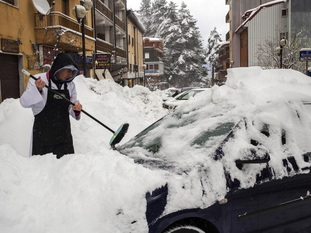 Homem remove a neve de um carro na cidade de Camigliatello, na Calábria, sul da Itália. A nevasca durou a noite toda e causou ventos fortes na região