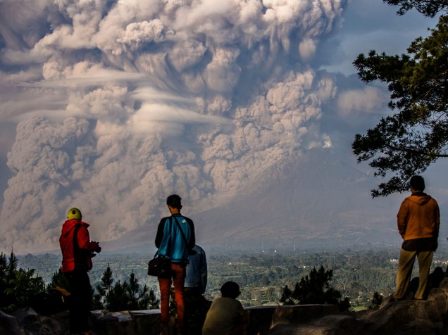 Moradores observam enorme nuvem de fumaça do vulcão Sinabung em Karo, na Indonésia