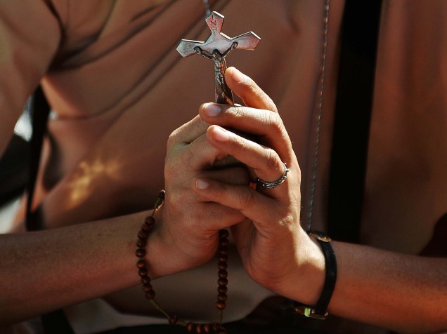 Mulher segura crucifixo durante protesto em Mumbai. Os cristãos pedem por ações contra os recentes ataques às igrejas na Índia