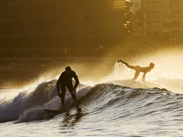 Surfistas desfrutam as ondas da praia de Zurriola de San Sebastián, na Espanha - 10/02/2015