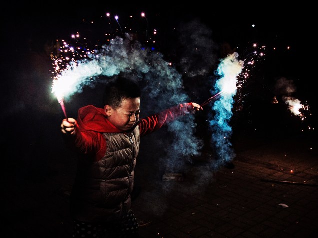 Menino chinês usa sinalizadores durante as comemorações do Ano Novo Lunar, em Pequim, China - 19/02/2015