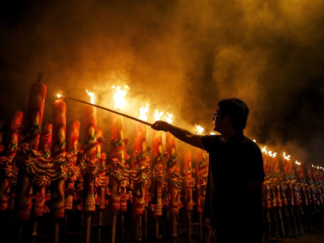 Homem acende pavis de incenso gigantes durante as celebrações do Ano Novo Chinês em Kajang, na Malásia
