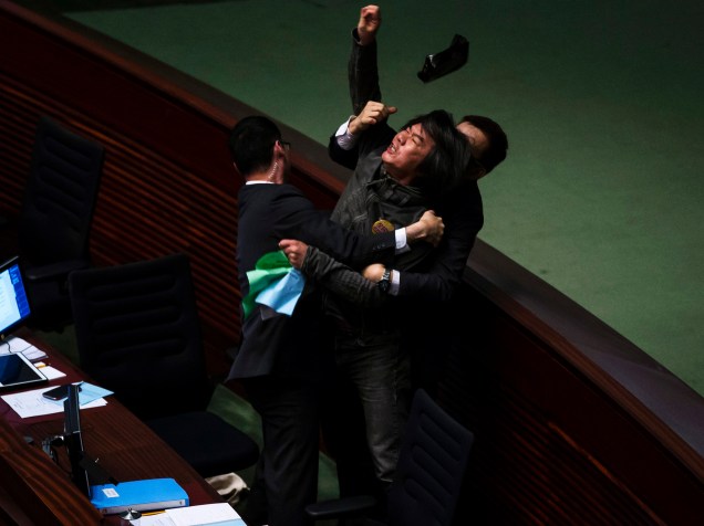 O parlamentar pró-democracia Leung Kwok-hung atira um objeto contra Secretário de Finanças de Hong Kong, John Tsang (fora do quadro) durante discussão no Conselho Legislativo local - 25/02/2015