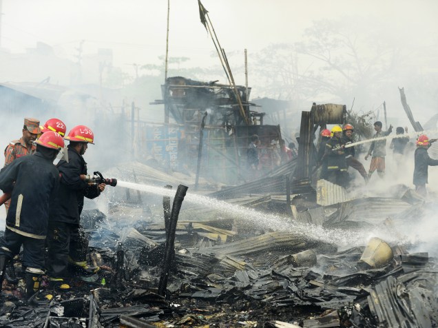 Bombeiros tentam controlar um incêndio em uma favela em Dacca, capital de Bangladesh, na Ásia - 25/02/2015