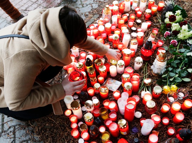 Mulher acende velas em homenagem as vítimas do tiroteio em Uhersky Brod (República Checa); um homem invadiu um restaurante, matou oito pessoas e atirou contra sí proprio em seguida - 25/02/2015