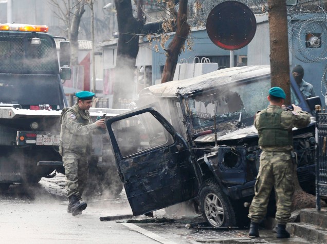 Soldados fotografam um veículo no local de um ataque suicida, em Cabul (Afeganistão). Um homem bateu seu veículo contra um carro carregado de explosivos da embaixada turca; uma pessoa morreu - 26/02/2015