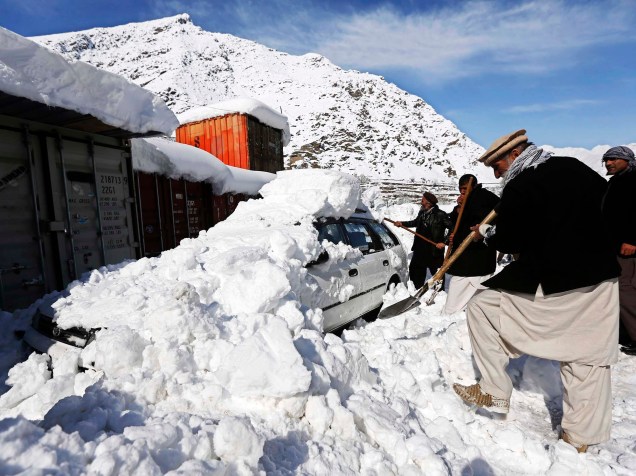 Homem afegão remove neve de cima de carro após avalanche em Panjshi, província do Afeganistão