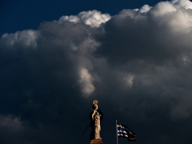 Bandeira grega tremula ao lado de uma estátua da deusa Atena, no centro de Atenas - 12/03/2015