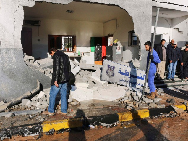 Agentes de segurança observam escombros após explosão em uma delegacia em Trípoli (Líbia). Militantes assumiram a autoria do ataque em uma declaração postada no Twitter - 12/03/2015