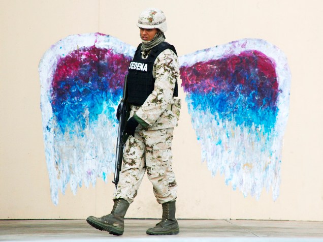 Soldado passa por um grafite de asas de anjo feito pelo artista Colette Miller, em Ciudad Juarez (México) - 19/03/2015