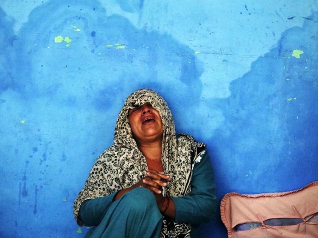A mãe de um policial indiano, que foi morto em um ataque a um acampamento da polícia, chora em sua residência no bairro Kathua, sul do estado de Jammu, região próxima à Caxemira - 20/03/2015