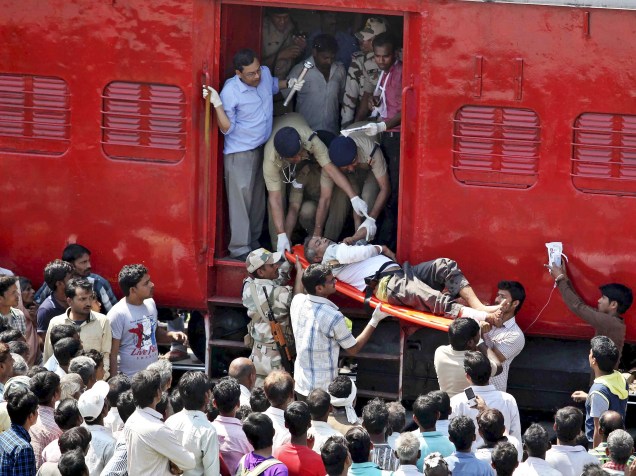 Passageiro indiano é socorrido após acidente de trem em Uttar Pradesh. O trem ultrapassou o sinal fazendo algumas carruagens saírem dos trilhos; pelo menos 30 pessoas foram mortas e 50 ficaram feridas - 20/03/2015