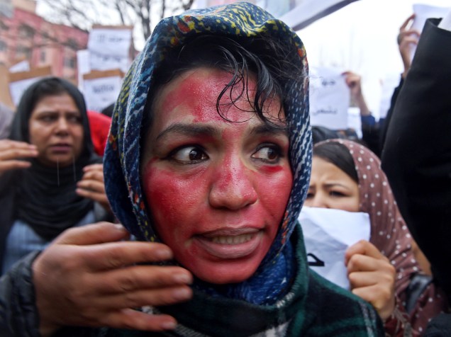 Manifestante afegã com o rosto pintado de vermelho para representar sangue, grita slogans durante um comício em frente ao Supremo Tribunal Federal em Cabul (Afeganistão); protestam contra a morte de uma mulher que foi espancada