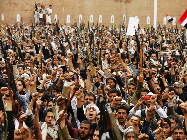 Rebeldes xiitas levantaram suas armas durante uma manifestação contra os ataques aéreos da Arábia Saudita, em Sanaa, capital do Iêmen