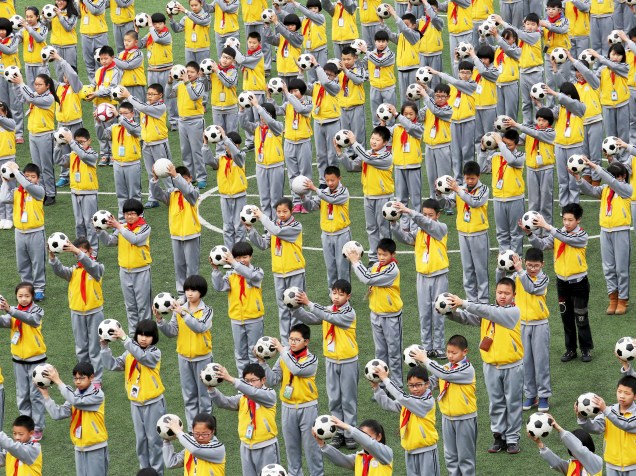 Estudantes chineses fizeram exercícios com bolas de futebol em uma escola de Linhai, província de Zhejiang