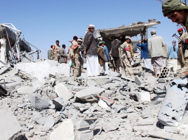 Soldados e guerrilheiros houthi inspecionam o dano causado pelos ataques aéreos no aeroporto do Iémen. A capital, Sanaa, foi atingida durante a noite por aviões de guerra - 30/03/2015
