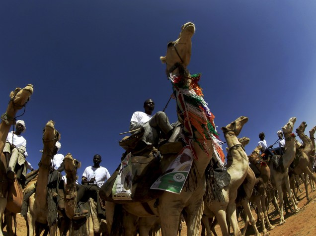 Apoiadores do Partido do Congresso Nacional (NCP, na sigla em inglês) e do candidato a presidência do Sudão, Omar Hassan al-Bashir, montam camelos durante campanha política para as eleições de 2015 - 08/04/2015