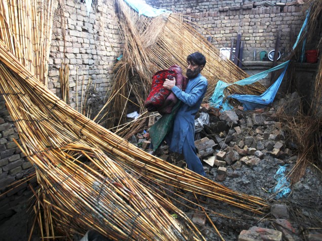 Homem recolhe seus pertences após forte chuva que destruiu centenas de casas na região de Peshawar, no Paquistão. Ao menos 45 pessoas morrem e cerca de 200 ficaram feridas - 27/04/2015
