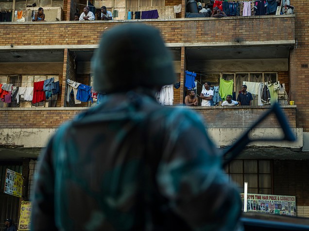 Oficiais de polícia sul-africanos patrulham com o auxílio de soldados das Forças de Defesa Sul Africanas, em Hillbrow, Joanesburgo, em busca de gangues que estão caçando e matando imigrantes - 27/04/2015