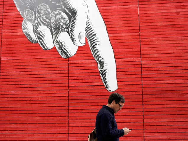 Homem passa por um grafite em uma parede no centro de Londres - 27/04/2015