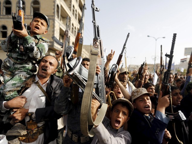 Garotos apoiando os Houthi levantam rifles em protesto contra os ataques aéreos liderados pela Arábia Saudita, em Sanaa, Iêmen - 27/04/2015