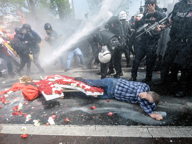 Homem se deita no chão enquanto policia utiliza canhão de água para dispersar manifestantes perto da Praça Taksim, em Istambul, na Turquia