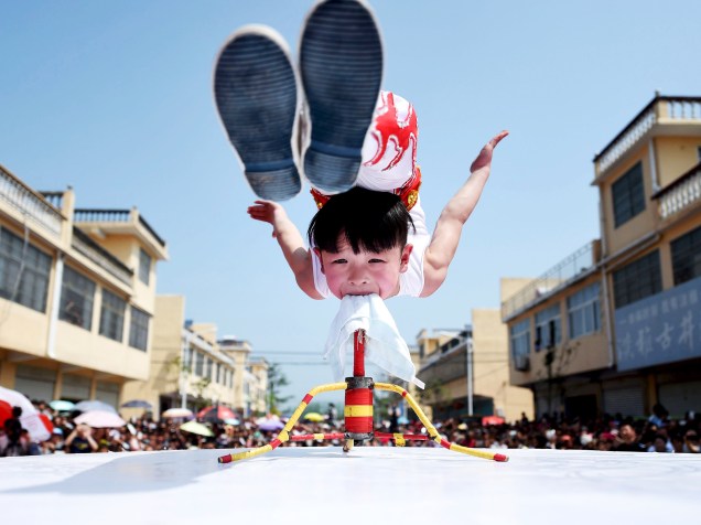 Menino de seis anos faz acrobacia durante festival de turismo em Bozhou, na província de Anhui, na China<br><br> <br><br>