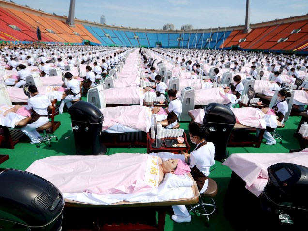 Cerca de mil pessoas recebem massagem facial ao mesmo tempo em um estádio em Jinan, na província de Shandong, na China, com o objetivo de quebrar o recorde mundial. As mulheres receberam tratamento facial por 30 minutos - 04/05/2015<br><br>