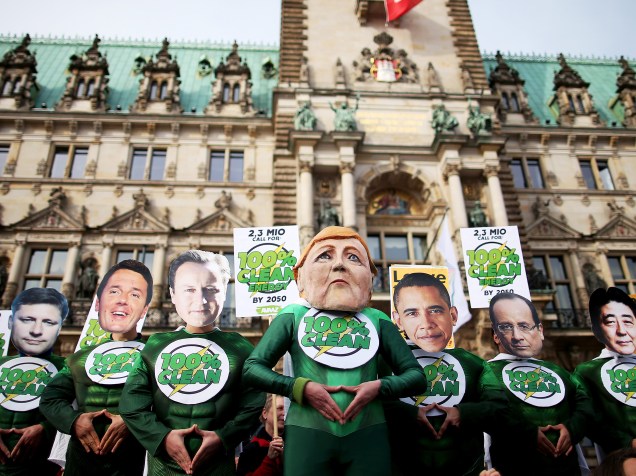 Membros da Avaaz usam máscaras com rostos de líderes políticos mundiais em frente à Câmara Municipal, em Hamburgo (Alemanha). Os manifestantes protestam por investimentos em energia limpa - 11/05/2015