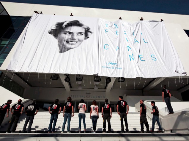 Com uma foto da atriz Ingrid Bergman, pessoas observam o poster oficial do 68º Festival de Cannes, na França - 11/05/2015