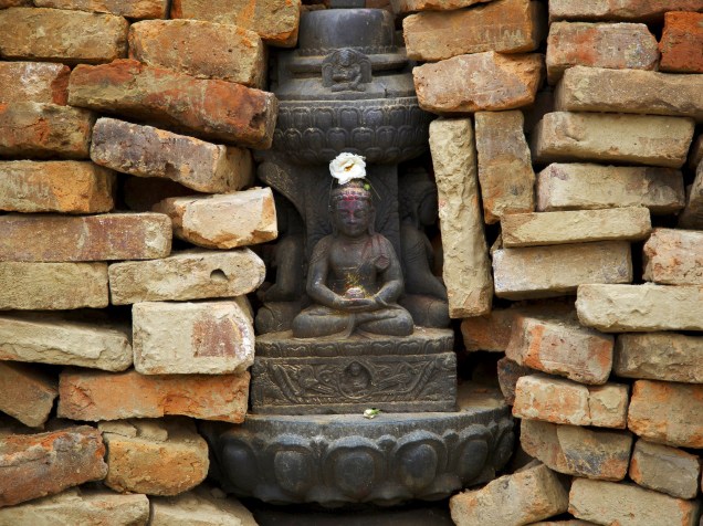 No templo de Bungamati, Nepal, tijolos são empilhados em volta de uma estátua de Buda - 11/05/2015