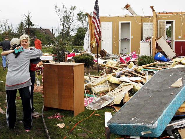 Mulheres se abraçam em meio aos destroços causados por um tornado que destruiu a região de Van, no Texas - 11/05/2015
