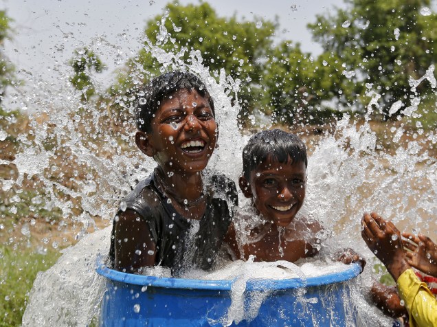 Garotos brincam com água para se refrescar na Índia, onde uma onda de calor já matou mais de mil pessoas na última semana - 28/05/2015