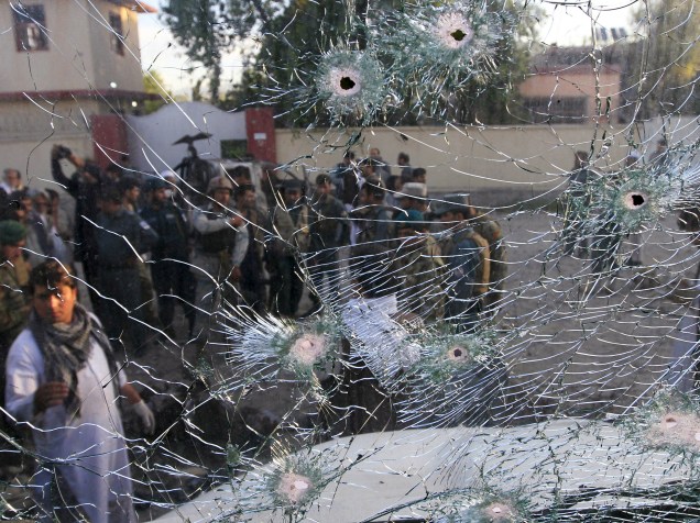 Forças de segurança afegãs são vistas através da janela quebrada de um veículo, que foi danificado por um ataque suicída em um quartel de polícia em Jalalabad, Afeganistão - 01/06/2015
