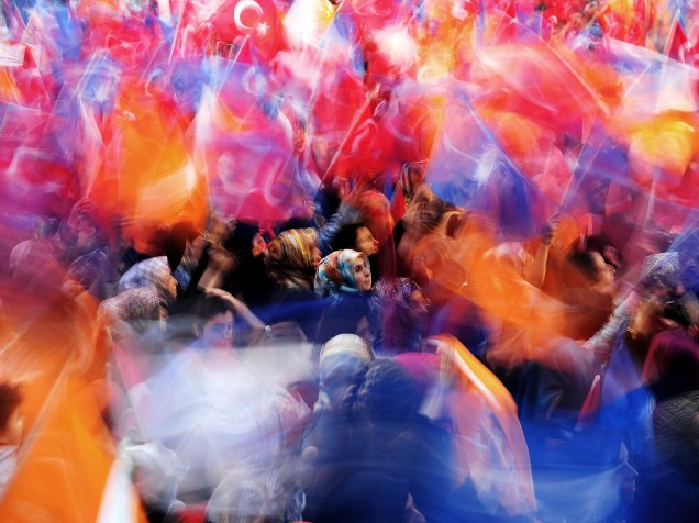 Militantes do Partido da Justiça e Desenvolvimento (AKP) acenam bandeiras durante um comício de campanha pelo primeiro-ministro turco Ahmet Davutoglu em Istambul