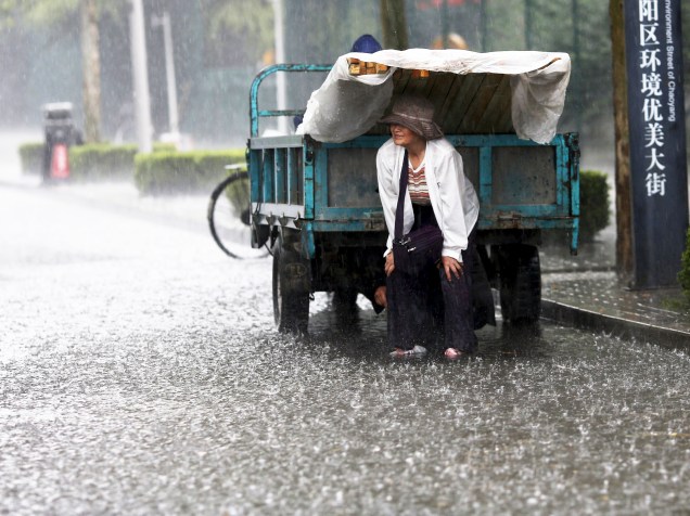 Mulher é fotografada enquanto se protege de forte chuva em Pequim, na China - 17/06/2015