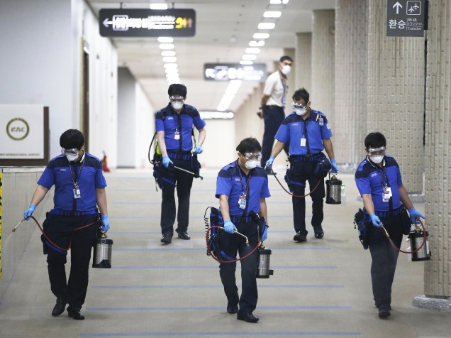 Funcionários de uma companhia sanitária usam máscaras durante higienização contra o vírus MERS no aeroporto internacional Gimpo, em Seul, Coreia do Sul - 17/06/2015