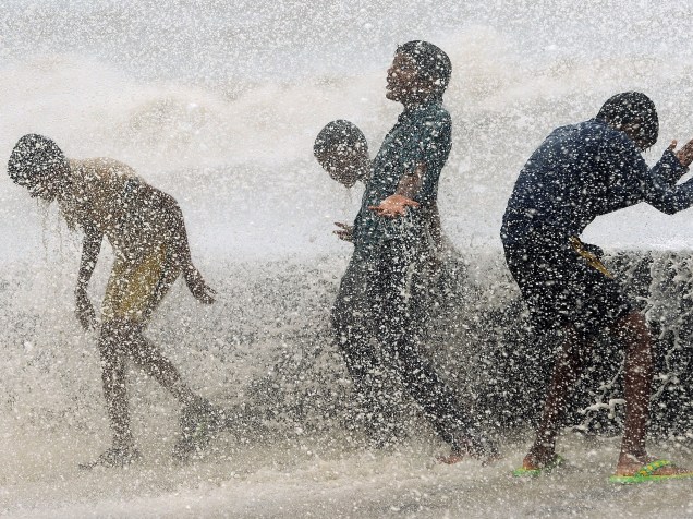 Crianças indianas brincam com as ondas durante a maré alta em Mumbai - 17/06/2015