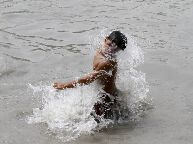 Homem toma banho em rio para se refrescar durante um dia quente em Peshawar, Paquistão. Onda de calor já foi responsável pela morte de mais de 400 pessoas em Karachi, Paquistão, nos últimos três dias - 23/06/2015