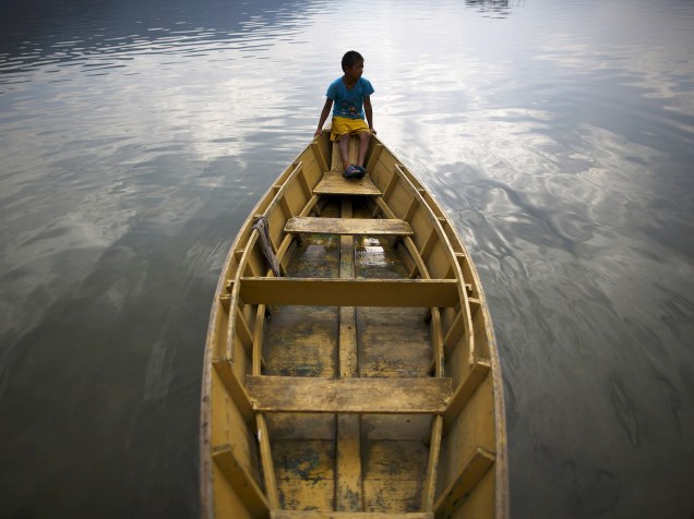 Garoto é fotografado sentado em um barco no lago Fewa, em Pokhara; o lago é considerado o segundo maior lago do Nepal - 29/06/2015