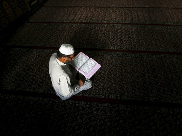 Homem é fotografado enquanto lê o Alcorão no interior de uma mesquita em Srinagar, na Índia - 07/07/2015