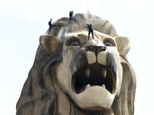 Em Singapura, equipe de limpeza realizou manutenção em estátua de 37 metros de altura com cabeça de leão e rabo de peixe que é o ícone turístico da Ilha de Sentosa