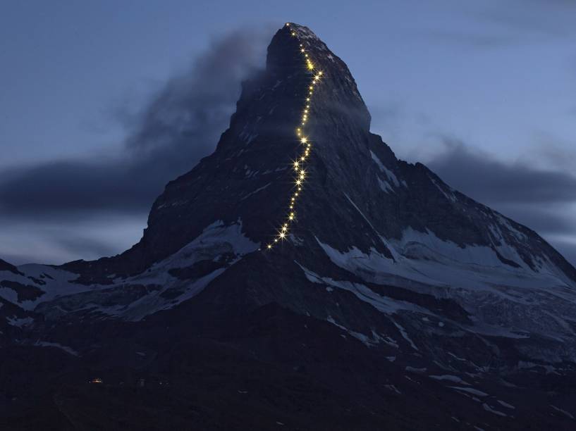 Luzes que funcionam com energia solar são vistas no cume Hornli na montanha Matterhorn, em Zermatt, Suíça.  A cidade celebra a primeira escalada feita na montanha, que ocorreu em 14 de Julho de 1865