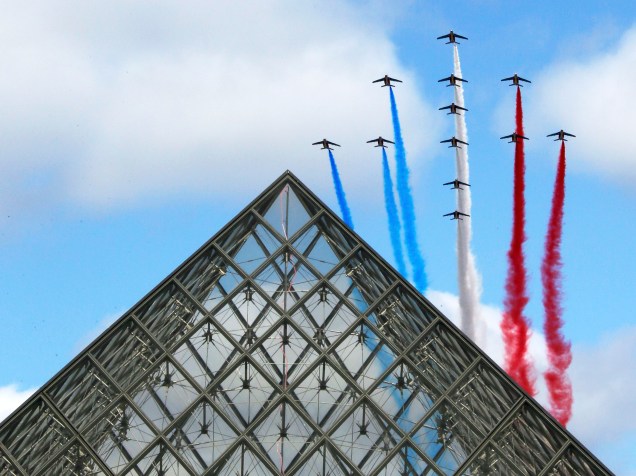 Alpha-Jets da Força Aérea Francesa fizeram acrobacias com as cores da bandeira nacional, durante o tradicional desfile militar em Paris